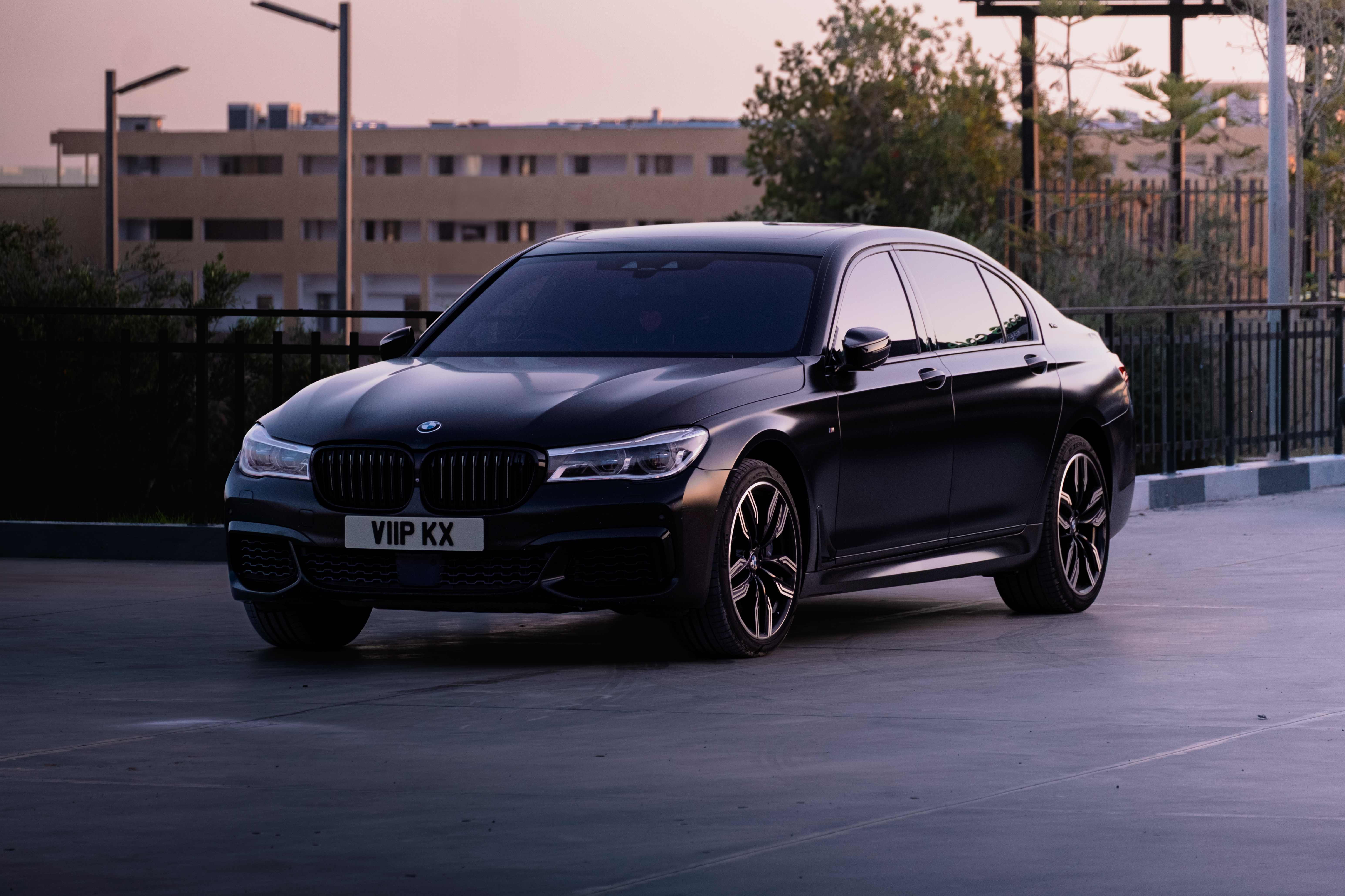 Black BMW 7 Series side profile in urban setting