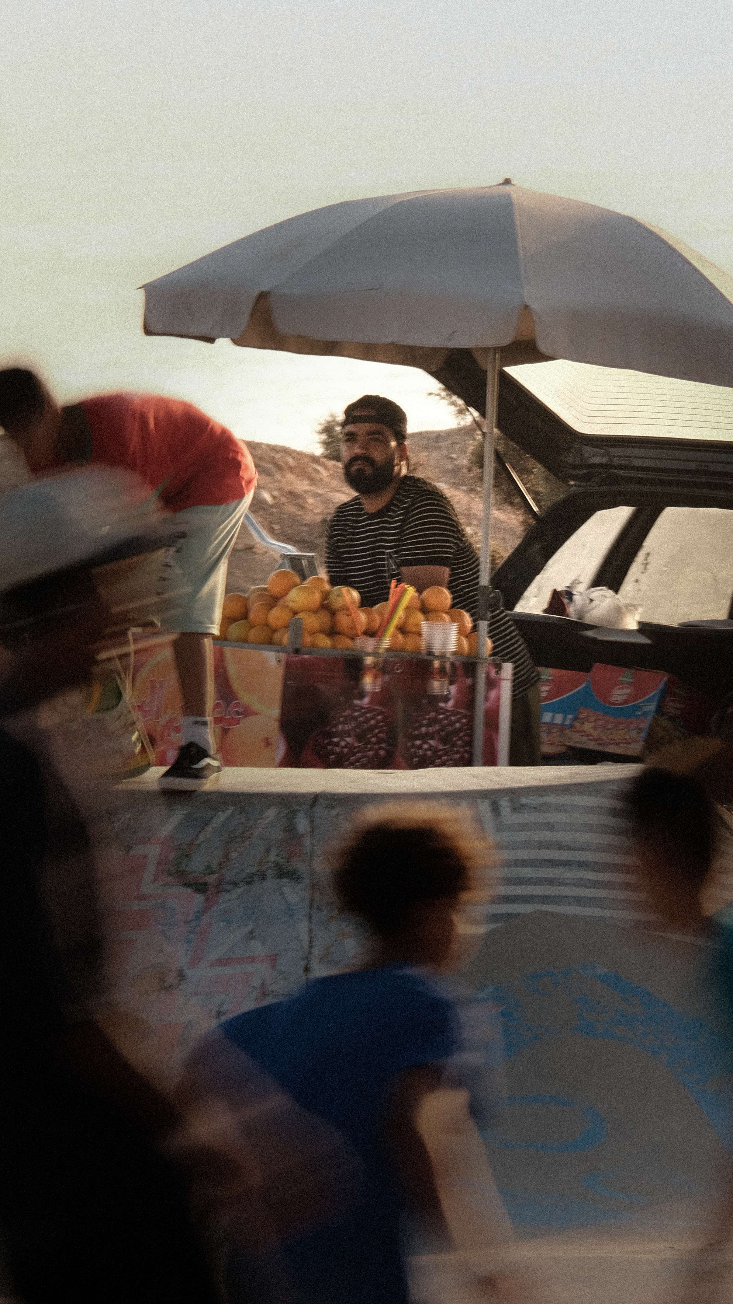 Candid street portrait of fruit vendor during golden hour