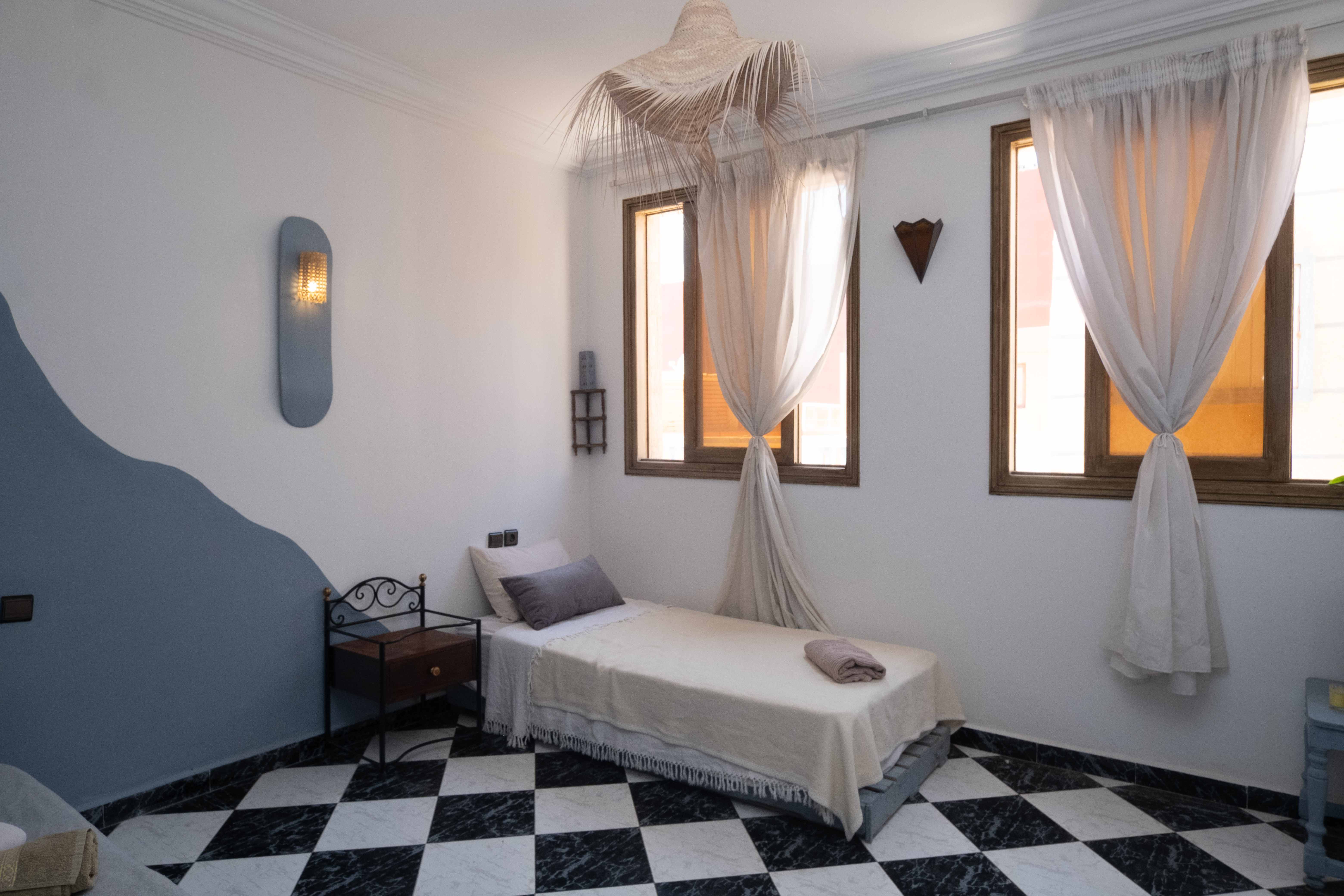 Bedroom with flowing white curtains and mosquito netting