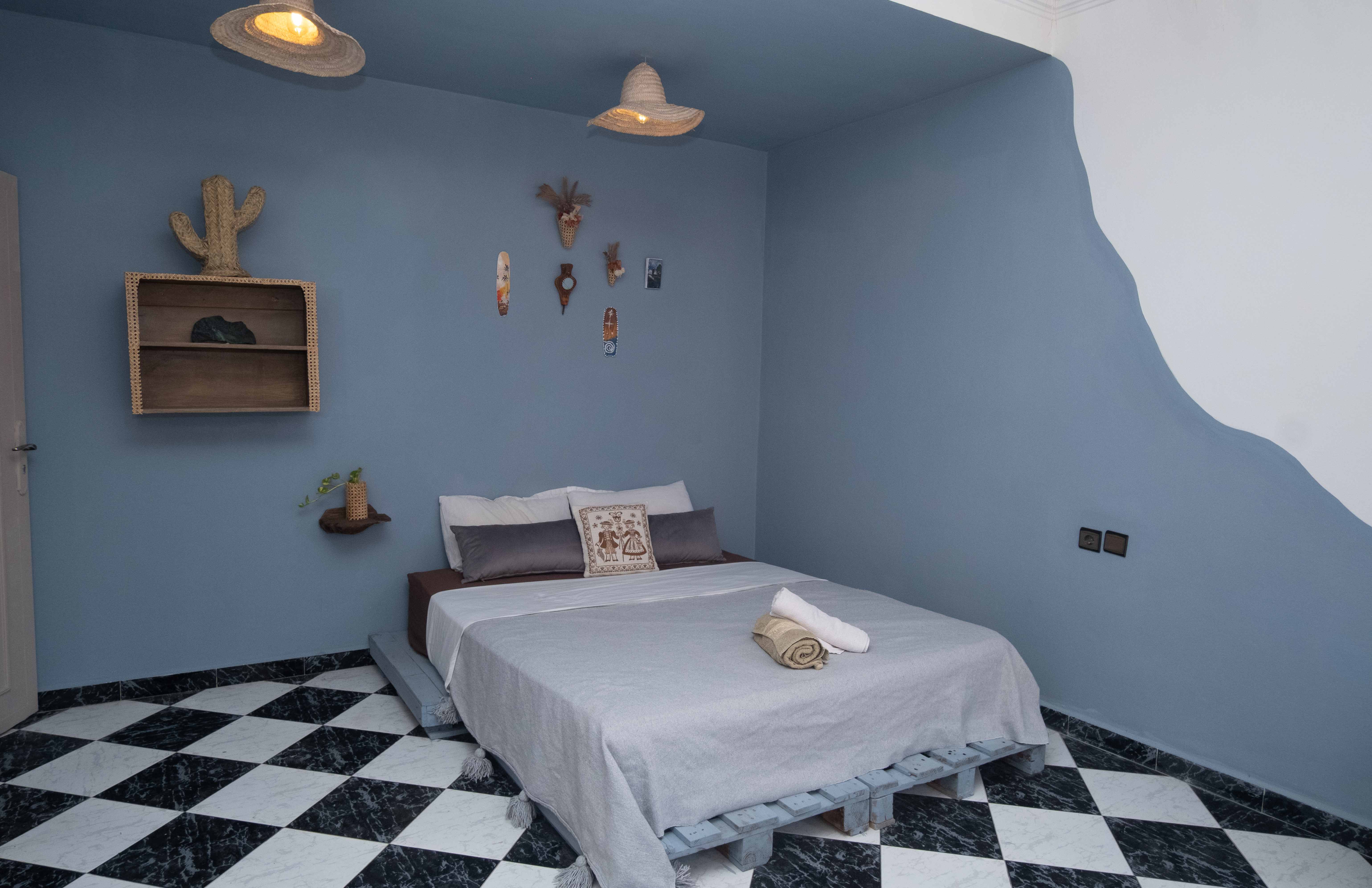 Blue bedroom with traditional Moroccan decor and wall art