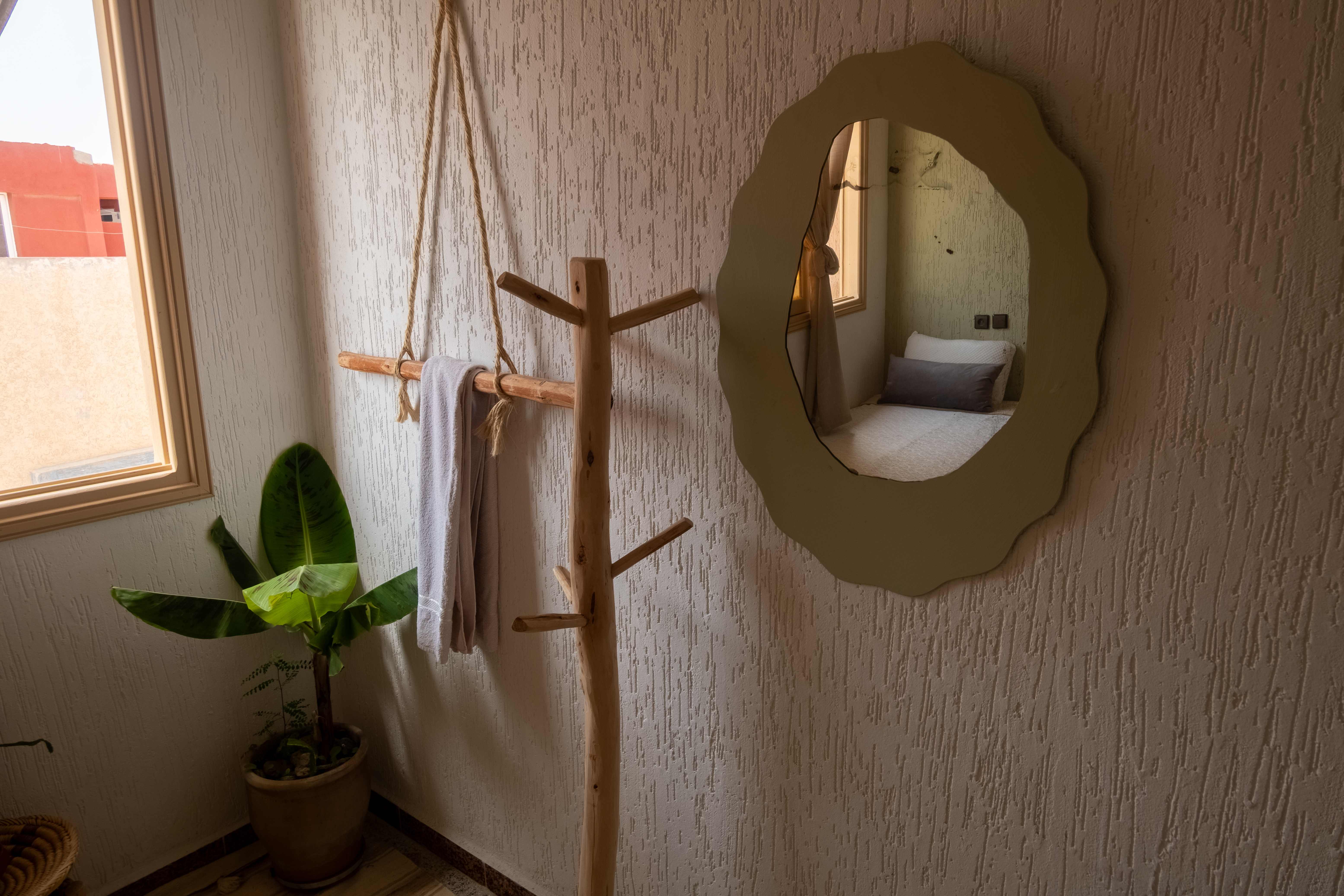 Interior design details with wooden coat rack and decorative mirror