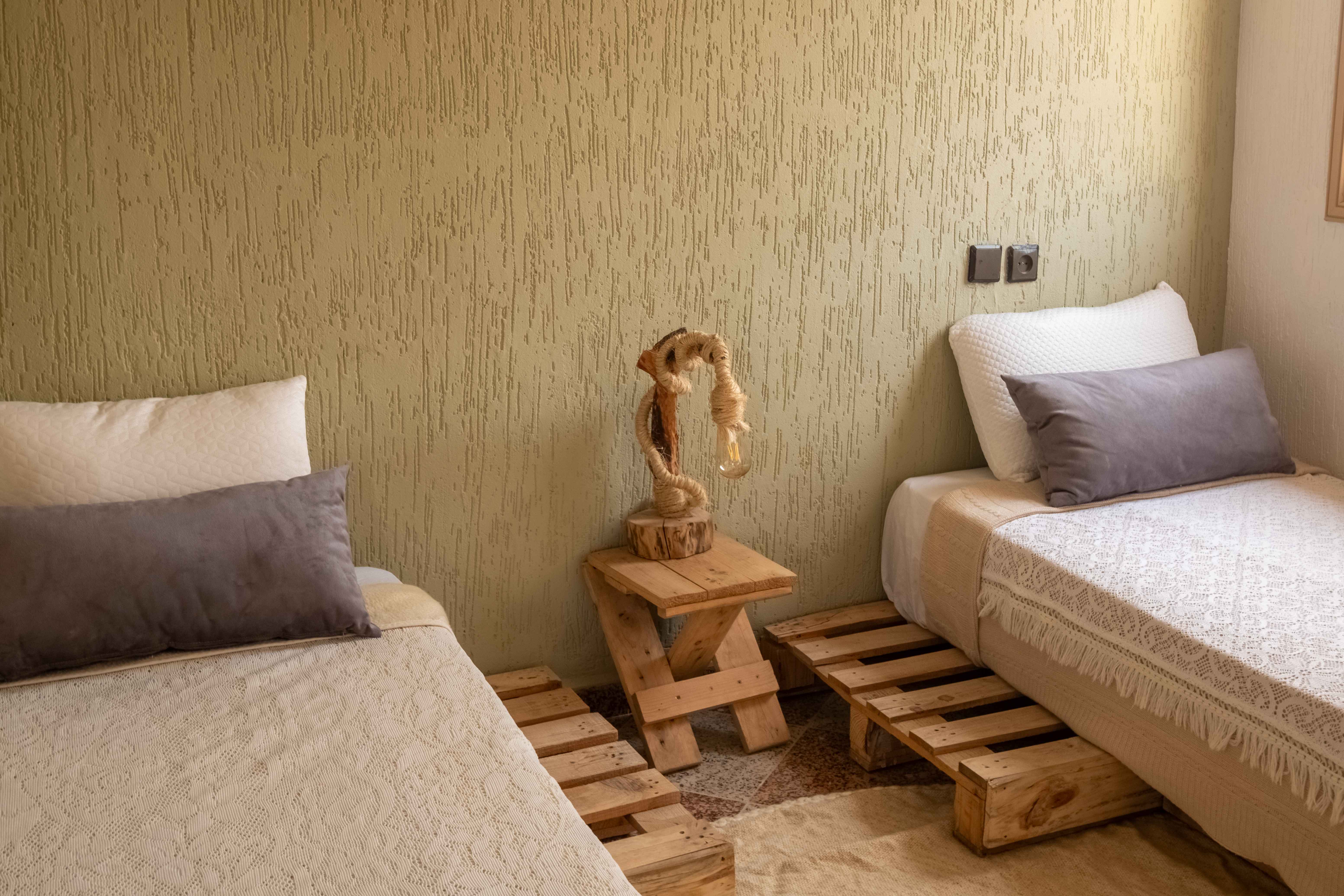 Twin bedroom with wooden pallet beds and rustic furniture