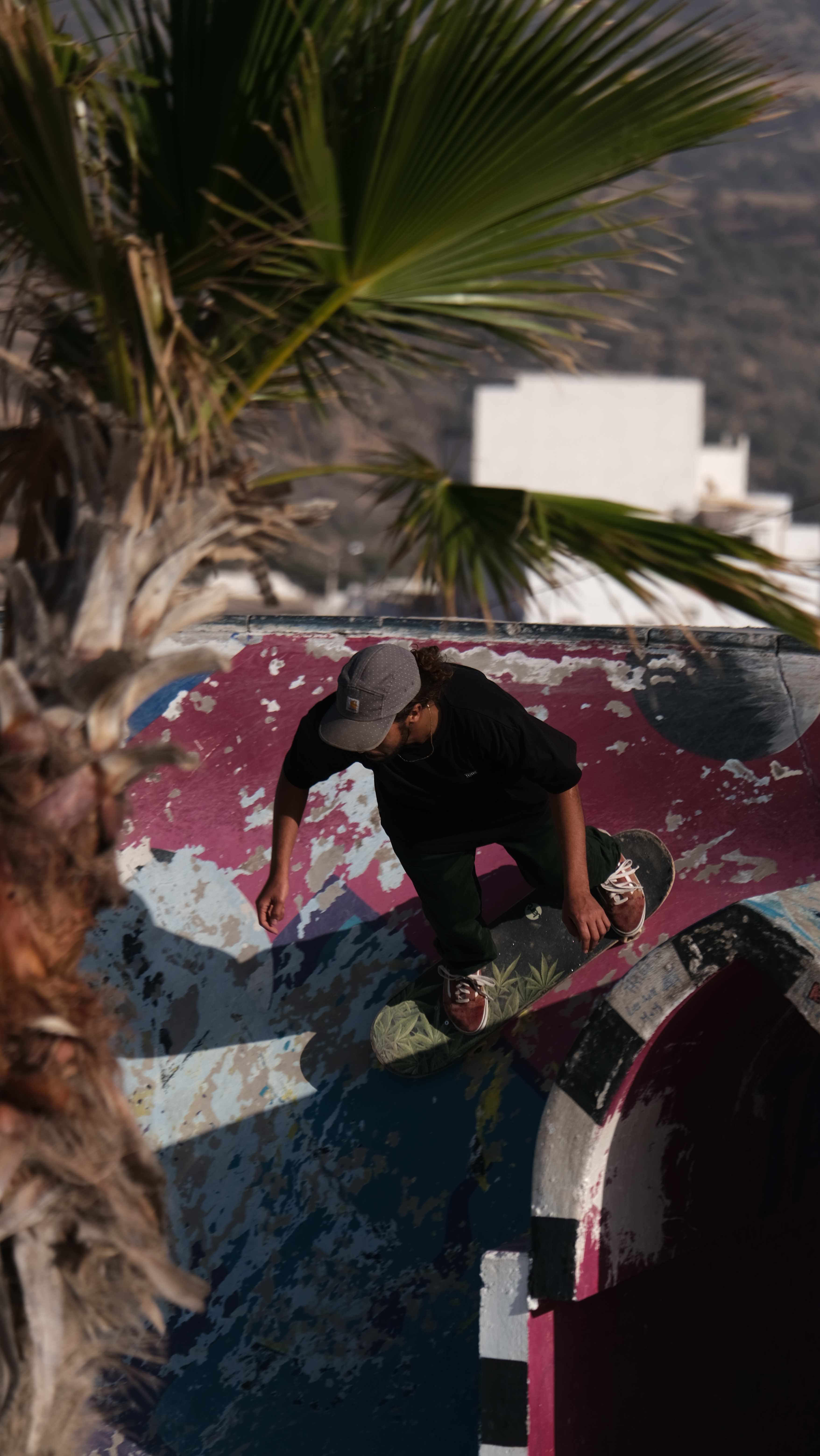 Skateboarder performing tricks in colorful concrete bowl