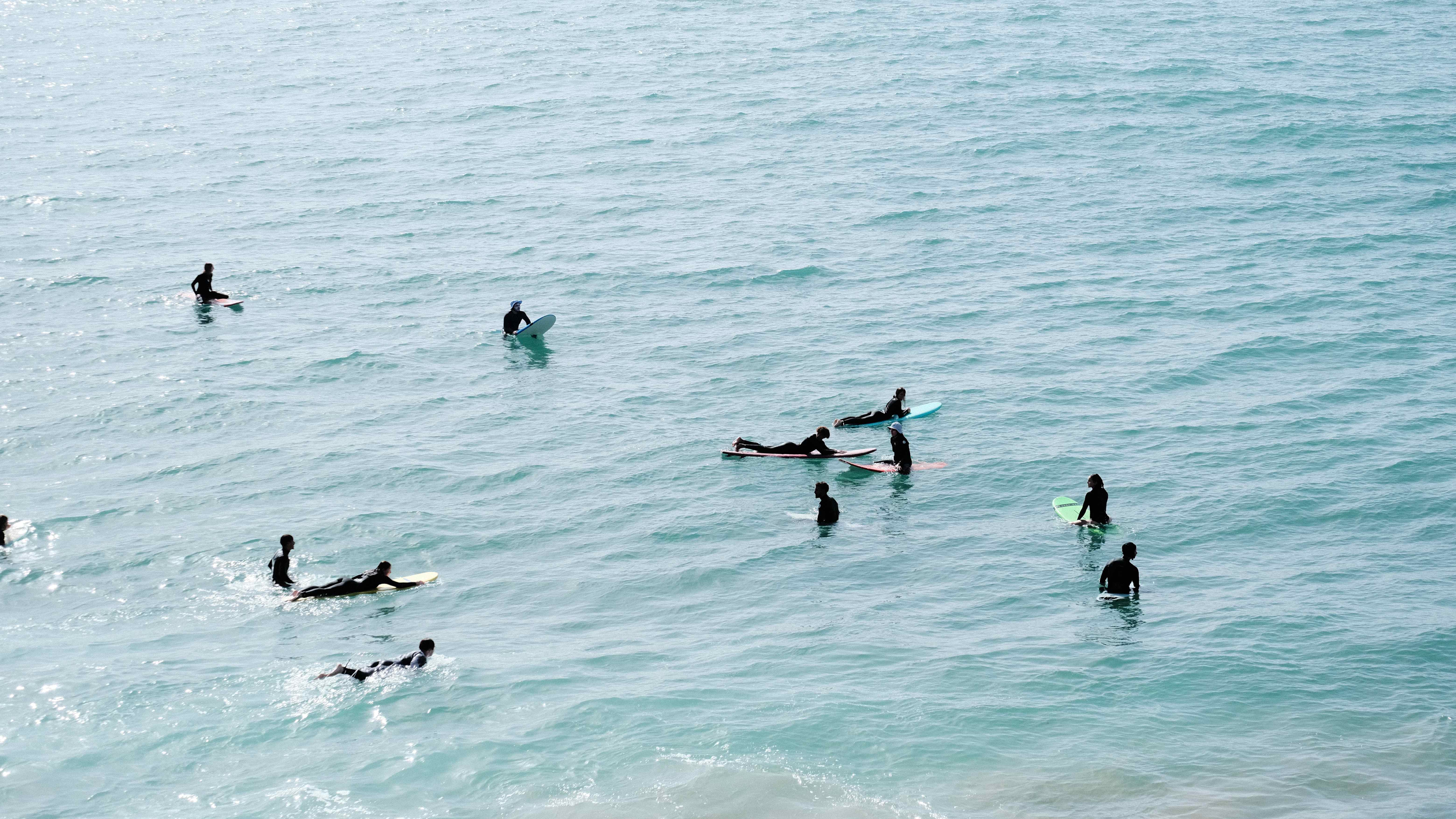 Multiple surfers in crystal clear turquoise water