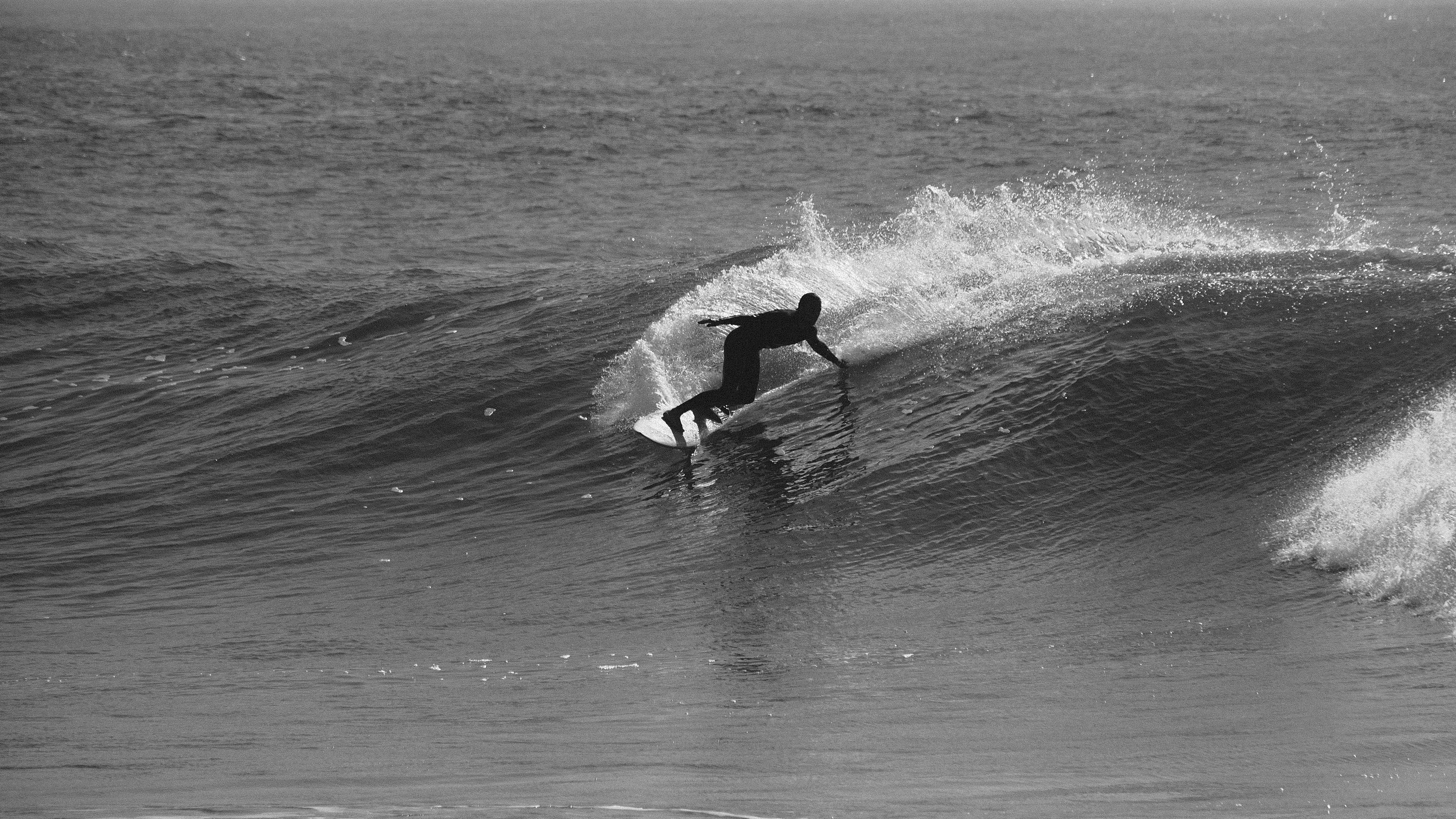 Black and white surfer riding wave